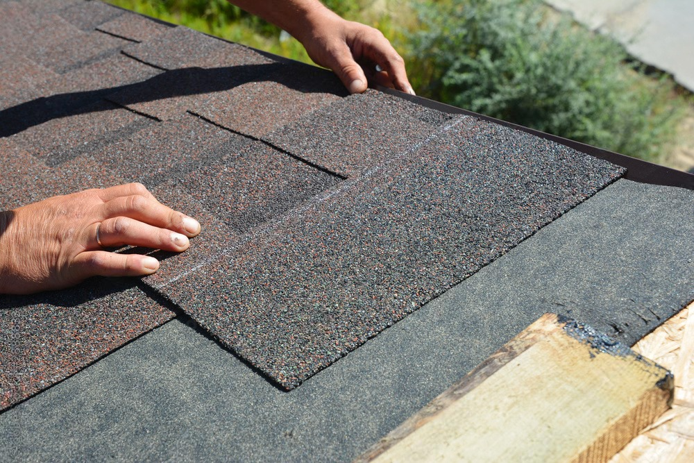 a person is installing shingles on a roof .