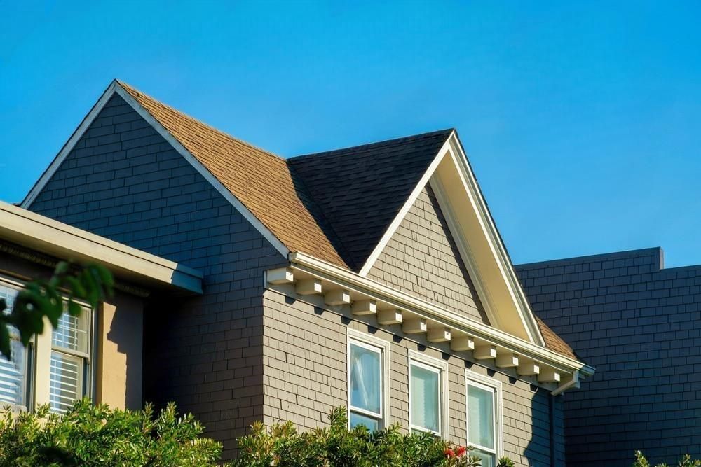 a house with a brown roof and a blue sky in the background