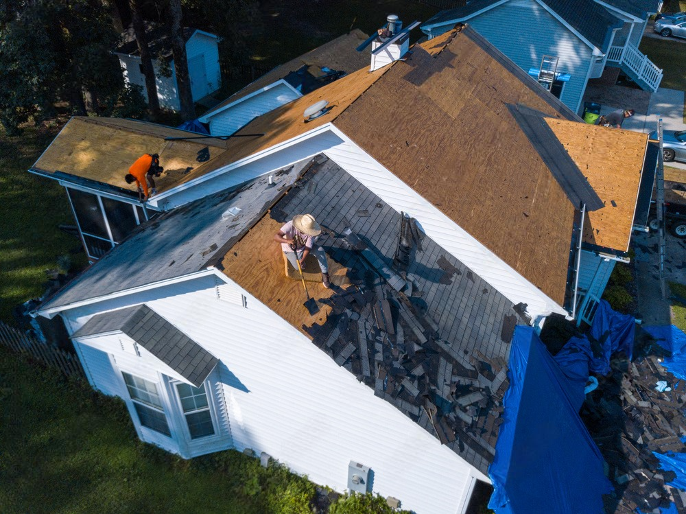 an aerial view of a house undergoing a roof replacement .