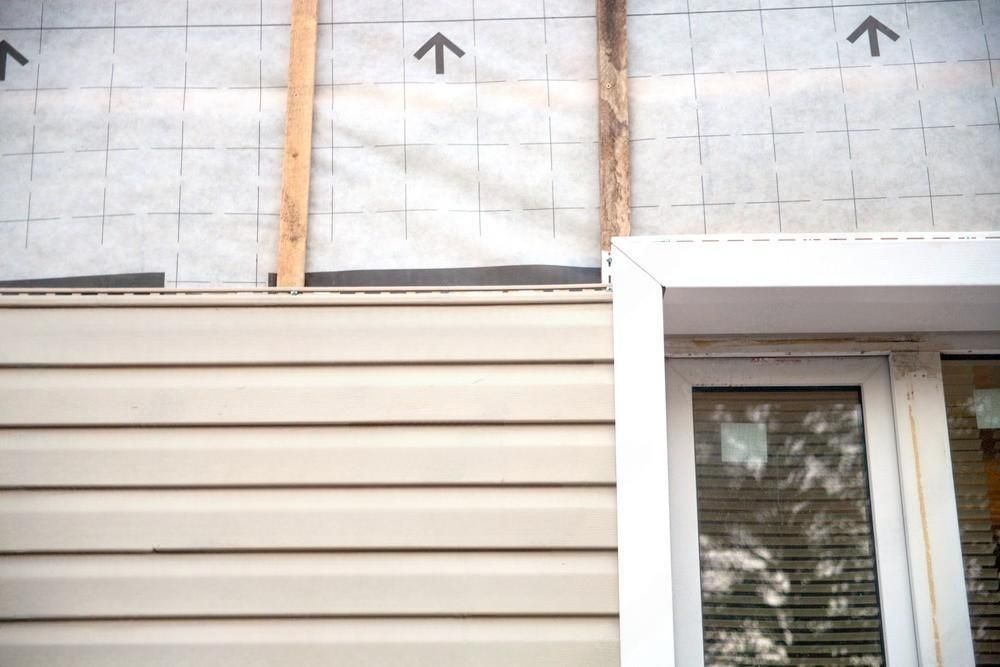 a window is being installed on the side of a house .