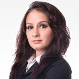 Woman with brown hair in a black blazer and white collared shirt.