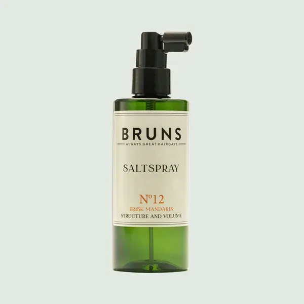Een groene spuitfles Bruns No. 12 Salt Spray voor structuur en volume, gecentreerd tegen een lichtgroene achtergrond.