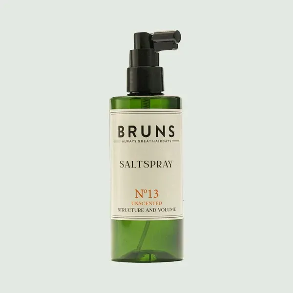 Een groene pompflacon van Bruns No. 13 Salt Spray voor het haar, met een wit etiket met zwarte en koperkleurige tekst.