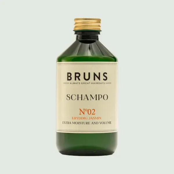 Een groene fles BRUNS No. 02 Shampoo, voor extra hydratatie en volume, met een gouden dop op een lichte achtergrond.