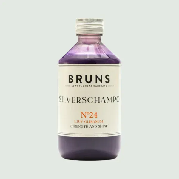 Een fles Bruns No. 24 Silverschampo met paarse vloeistof, een wit etiket en een zilveren dop.