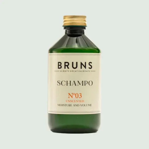 Een groene glazen fles BRUNS No. 03 ongeparfumeerde shampoo met een gouden dop tegen een lichte achtergrond.