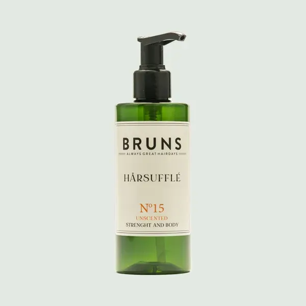Een pompflacon van Bruns No. 15 Hårsufflé haarproduct met een groene plastic fles en een beige etiket op een lichte achtergrond.