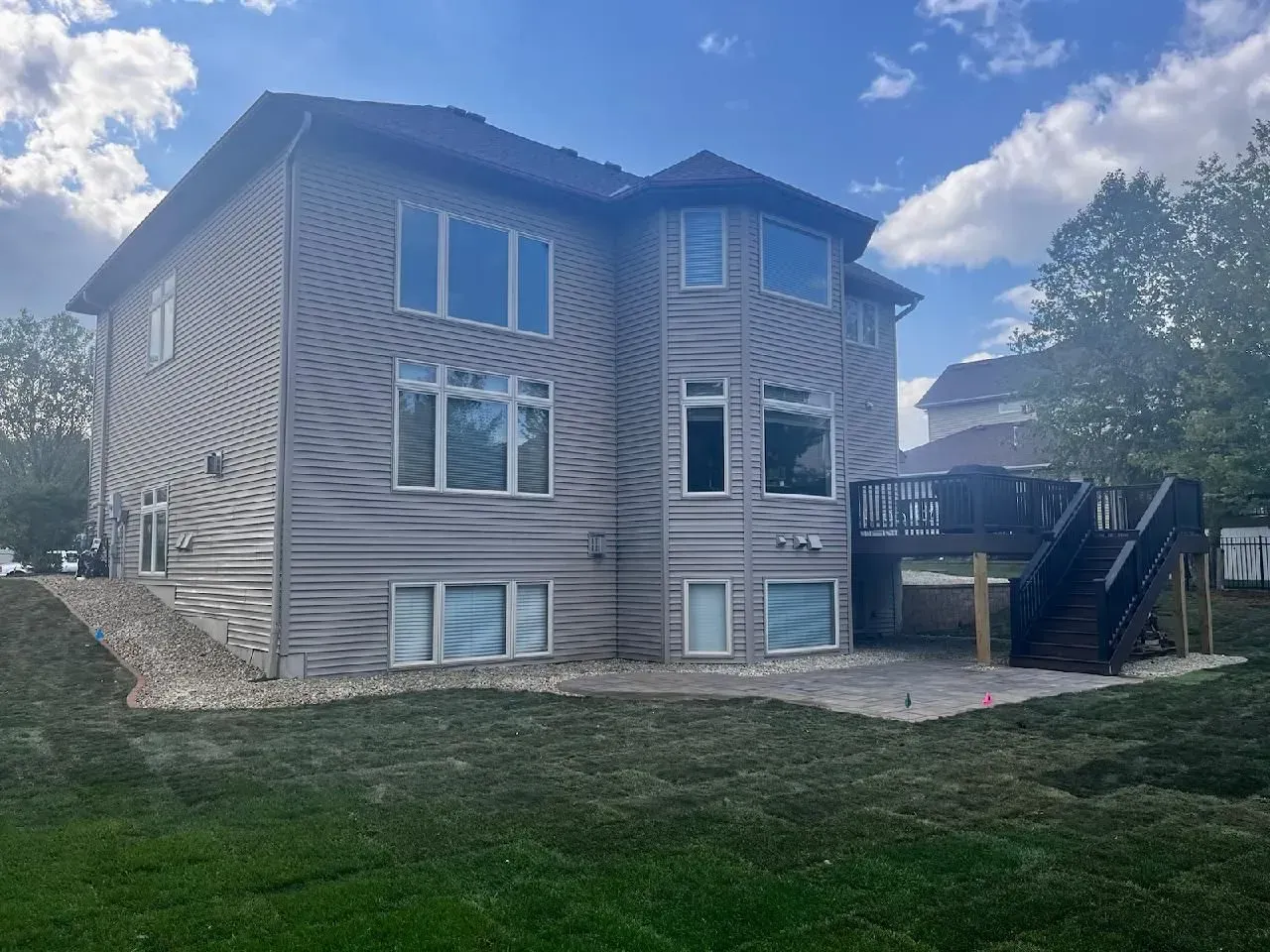 Back of a two-story gray house with multiple windows. 