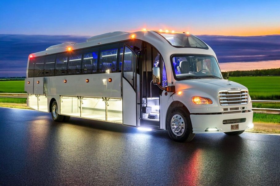 A white bus is parked on the side of a road.