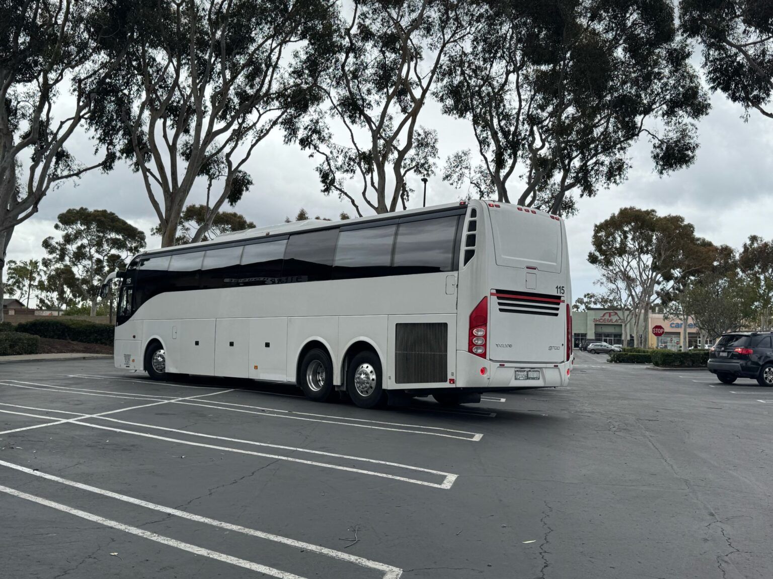 A large white bus is parked in a parking lot.