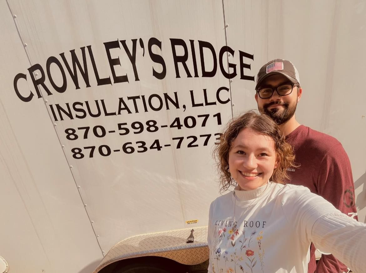 A smiling woman takes a selfie with a man in front of a truck with 
