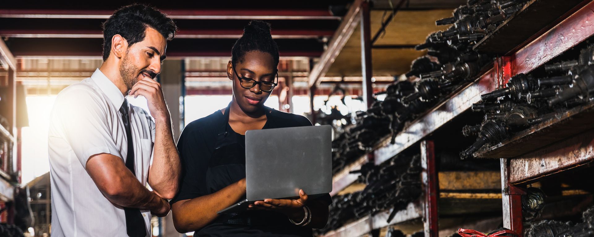 Old auto parts seller check on laptop.