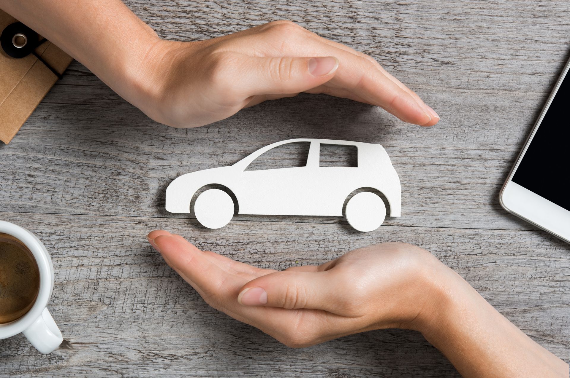 Hands protecting a car to represent auto insurance. Hands protecting a car to represent auto insurance.
