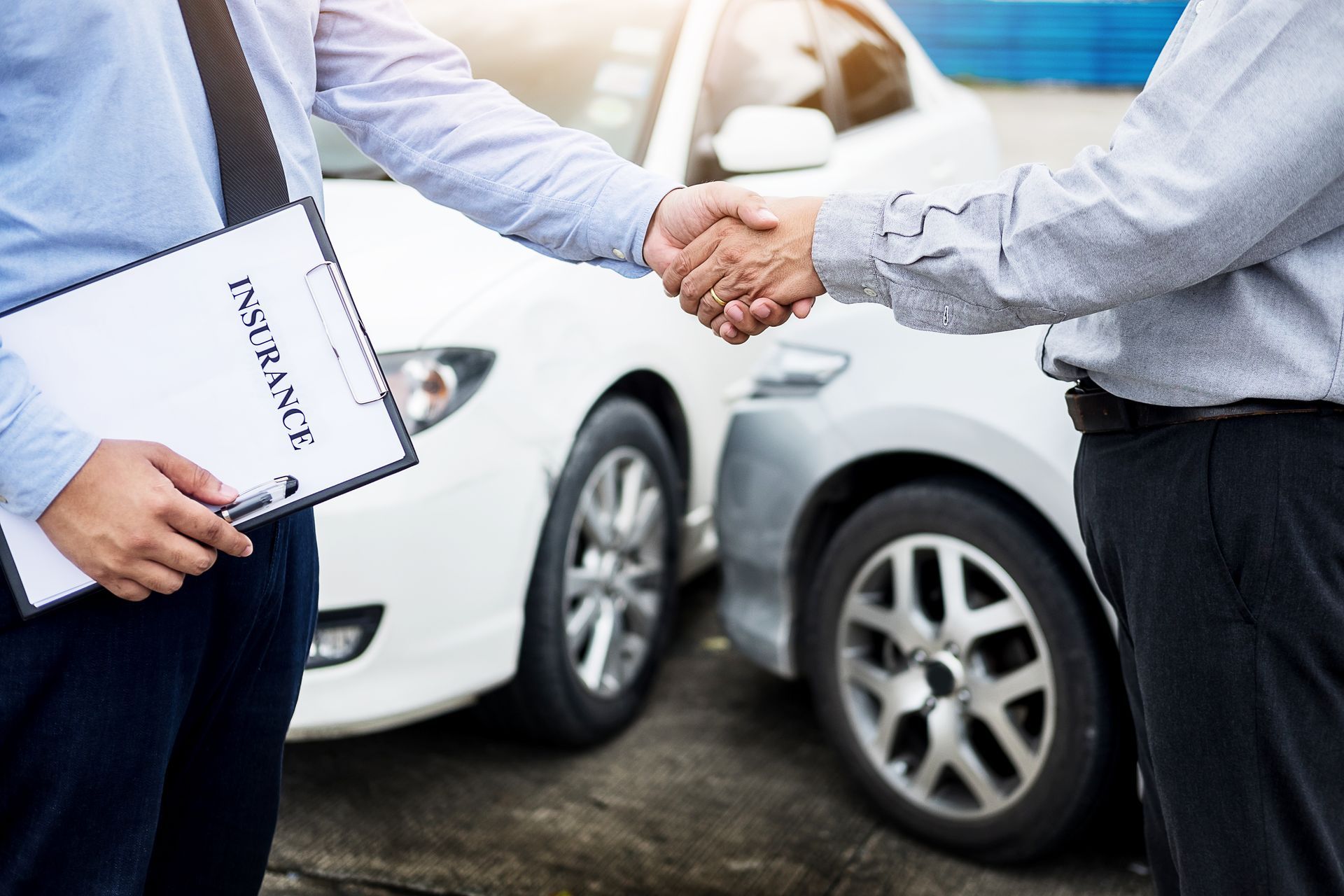 The customer shakes hands with the auto insurance agent.