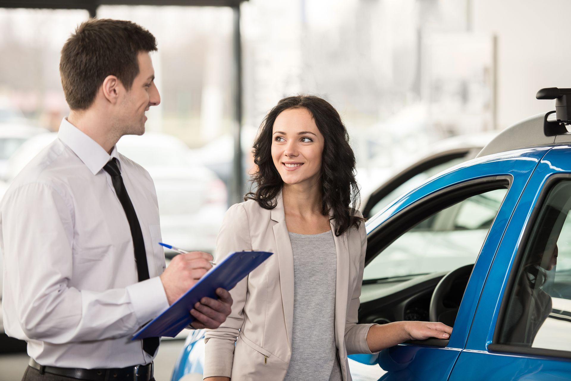 Woman at car salon with consultant choosing a car.