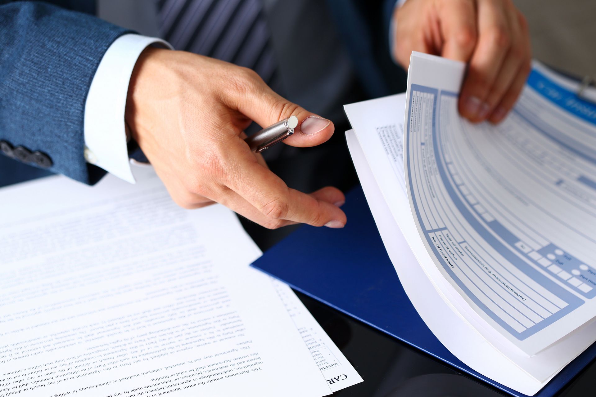 Close-up picture of an auto insurance specialist checking paperwork