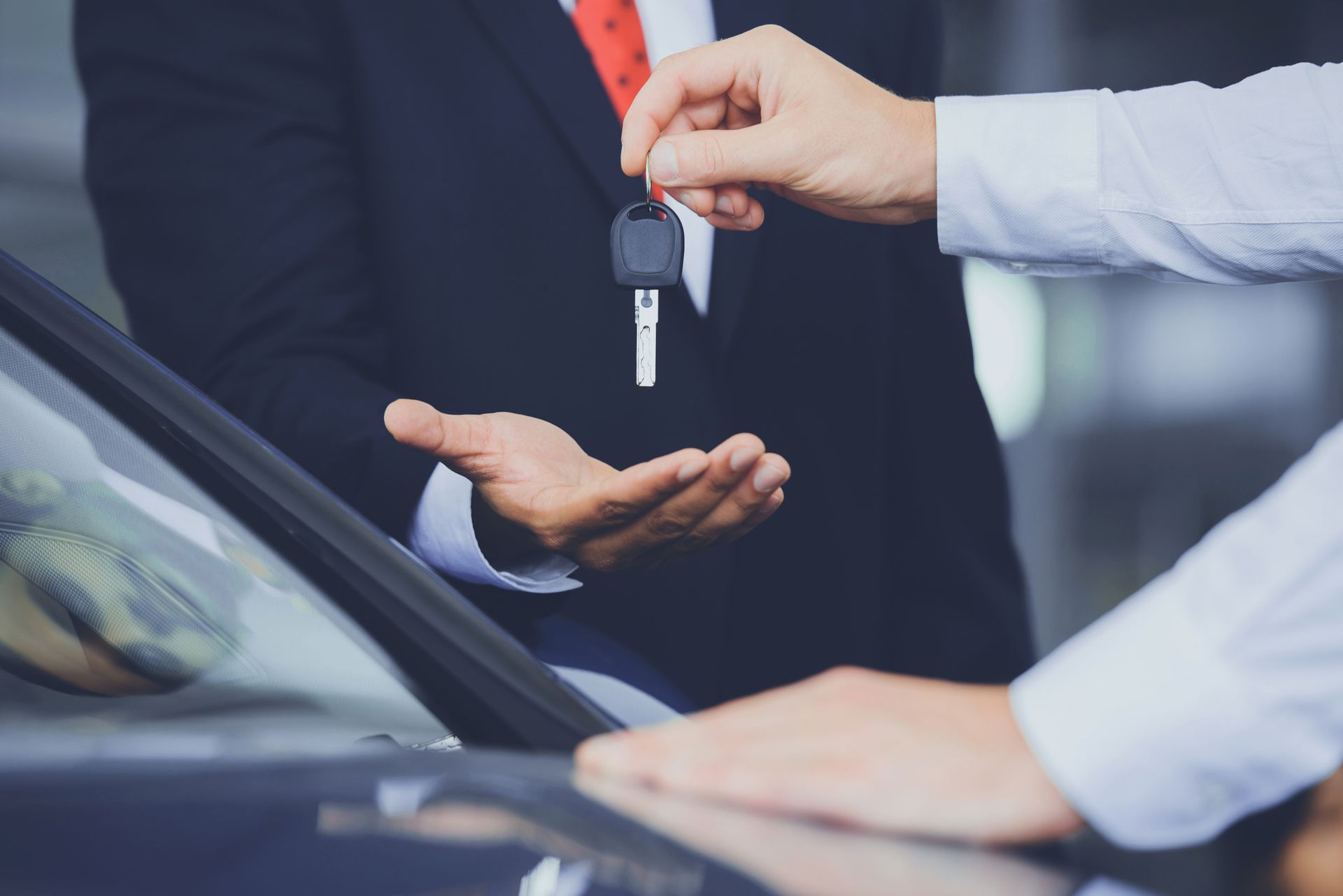 Close up of dealer giving key to new owner.