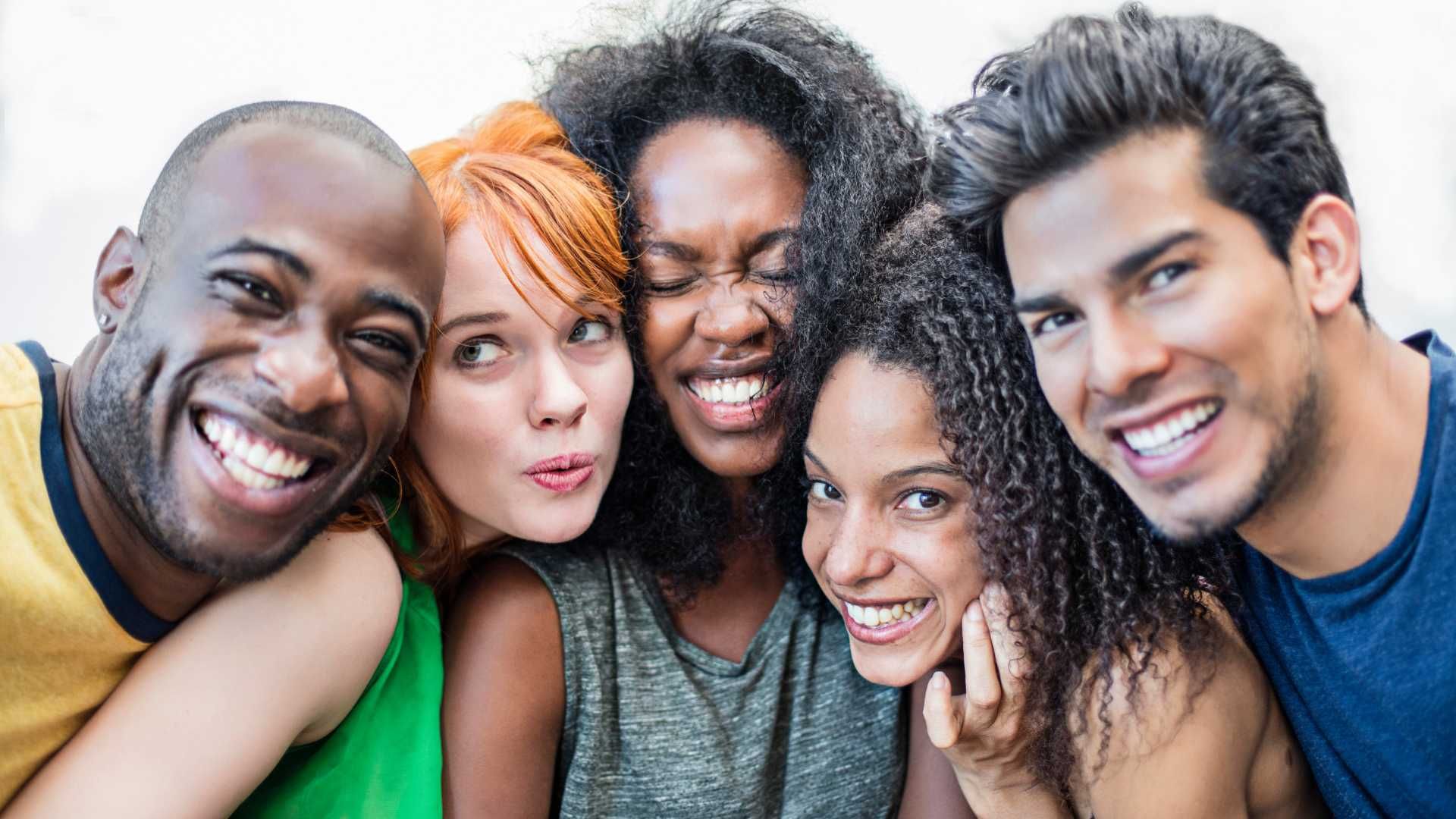A group of young people are posing for a picture together and smiling.