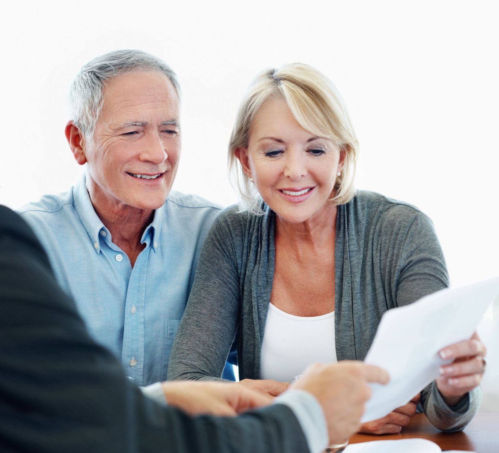 A man and a woman are sitting at a table looking at a piece of paper.
