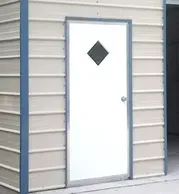 A white door with a diamond in the window on the side of a building.