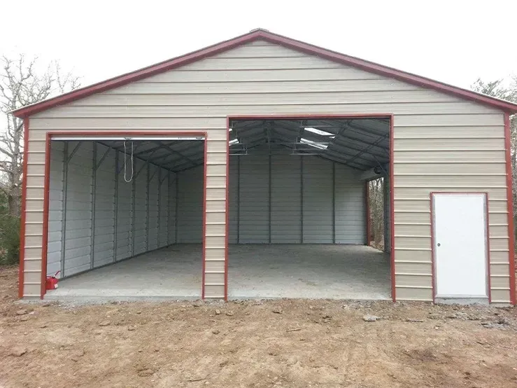 a metal garage with a red roof and a white door