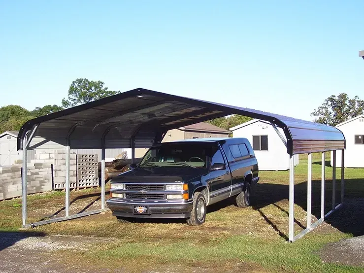 a black chevy truck is parked under a carport