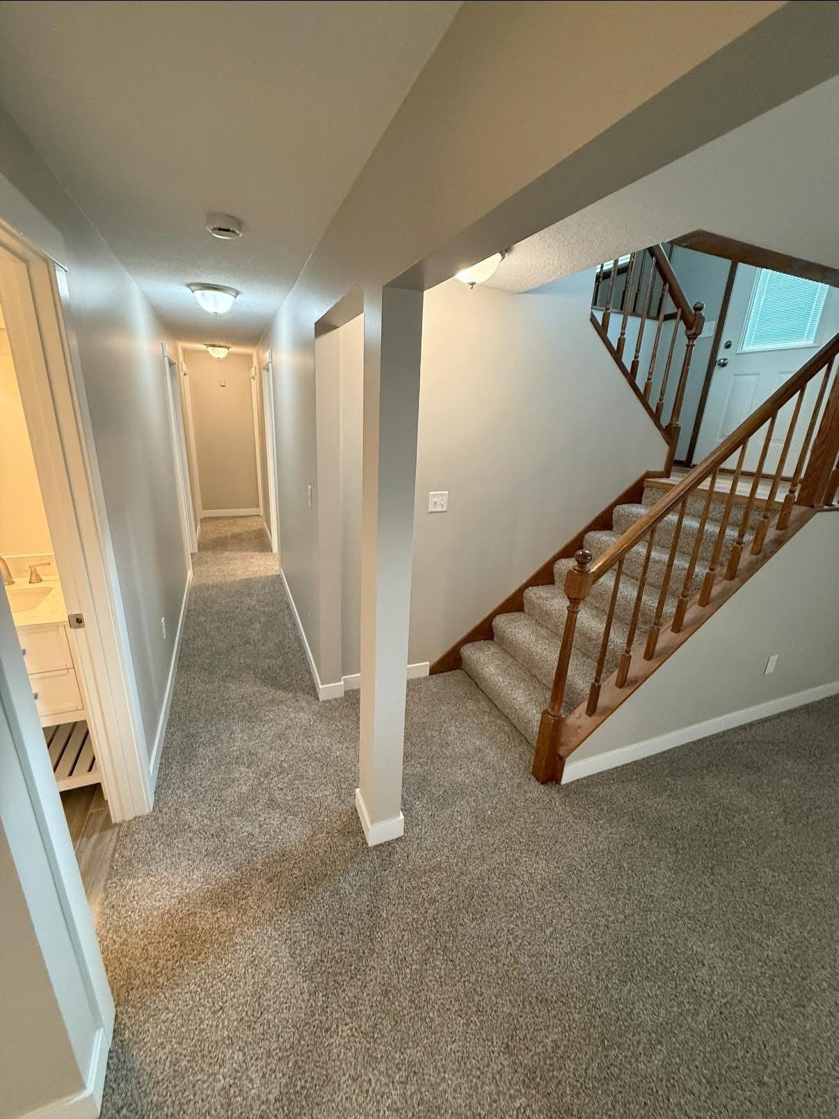 Kitchen with brown cabinets, carpet, appliances, and a glass-doored cabinet.