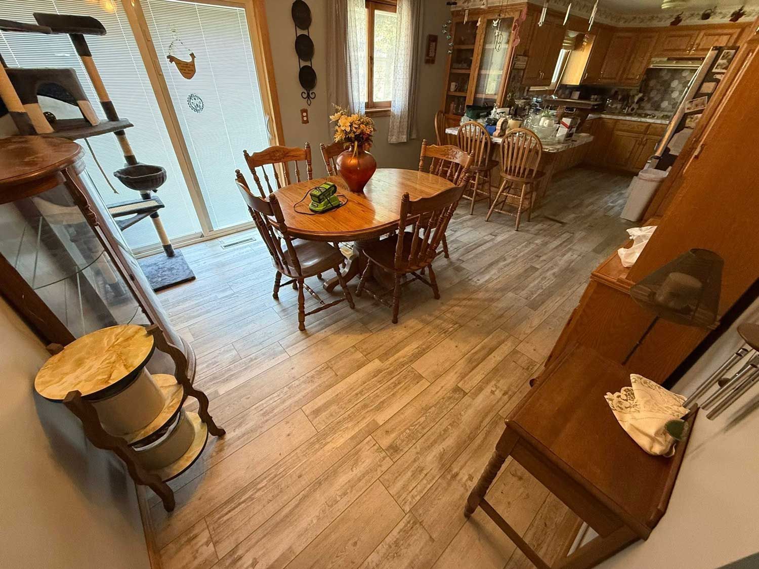 Shiny, brown hardwood floor reflecting light from sheer white curtains.