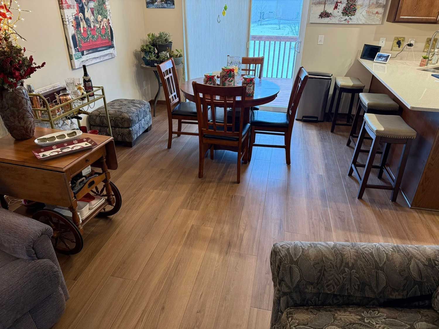 A dining area with a round table and chairs, adjacent to a kitchen island with bar stools.