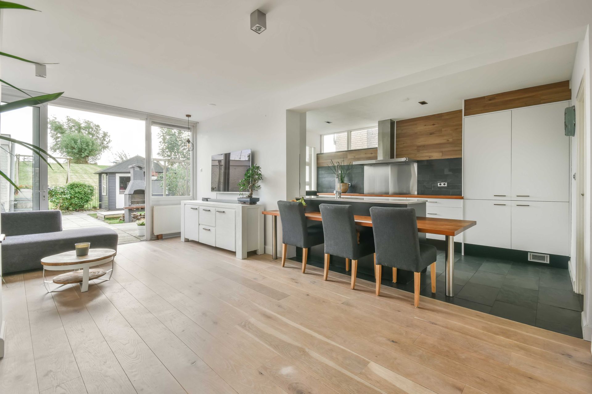 Open-concept living space with a dining area, kitchen, and living room leading to a backyard.