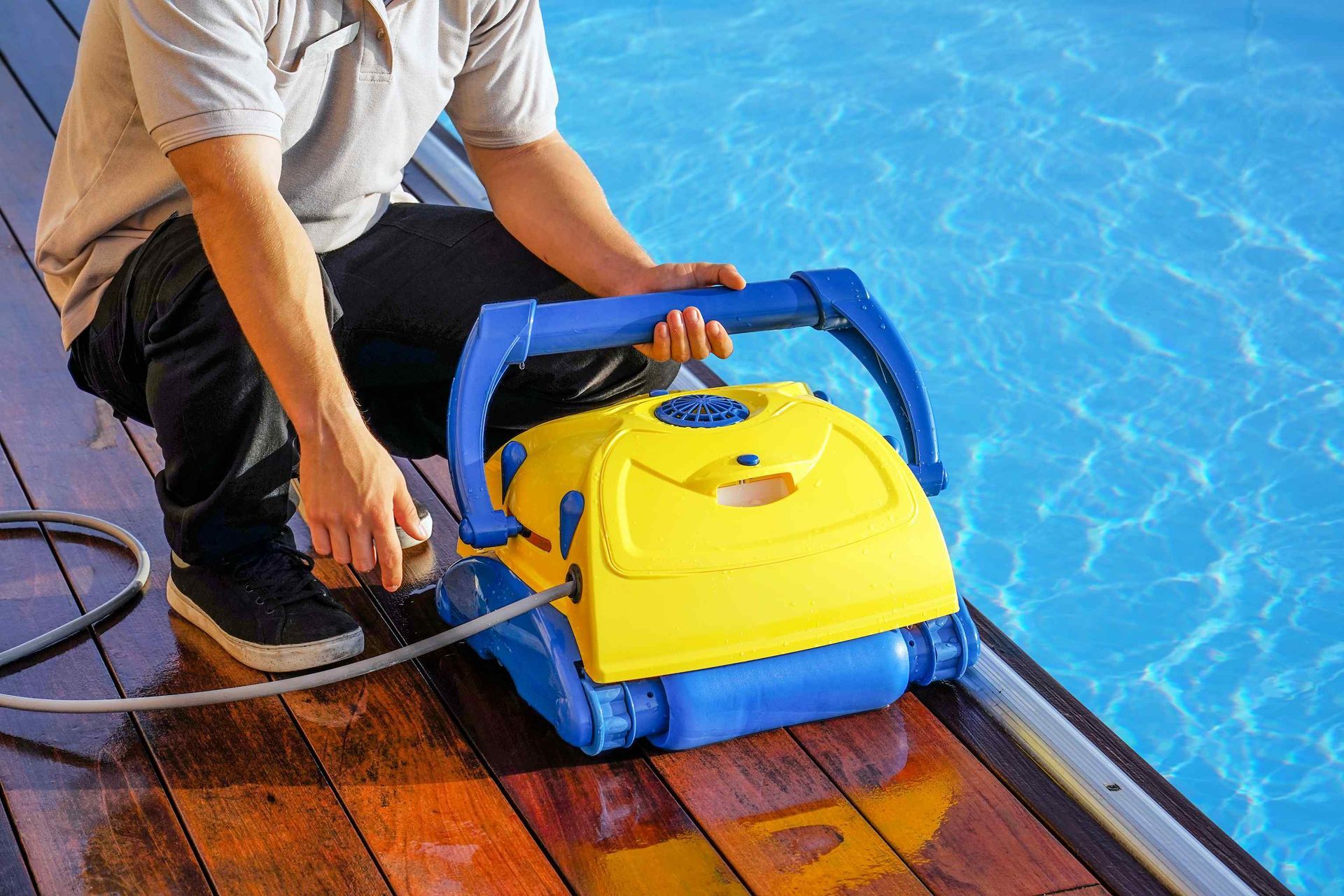 Worker using pool cleaning equipment