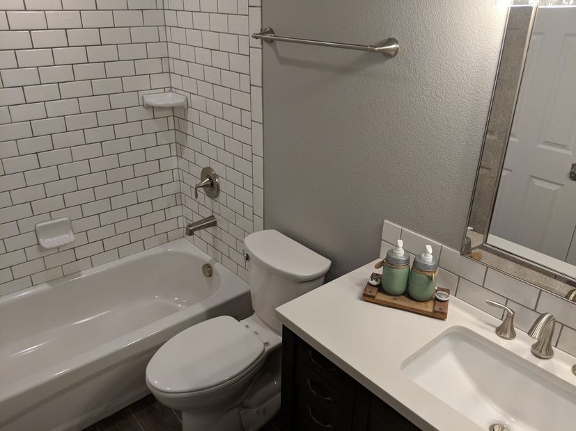 A bathroom with two sinks , a toilet , and a walk in shower.