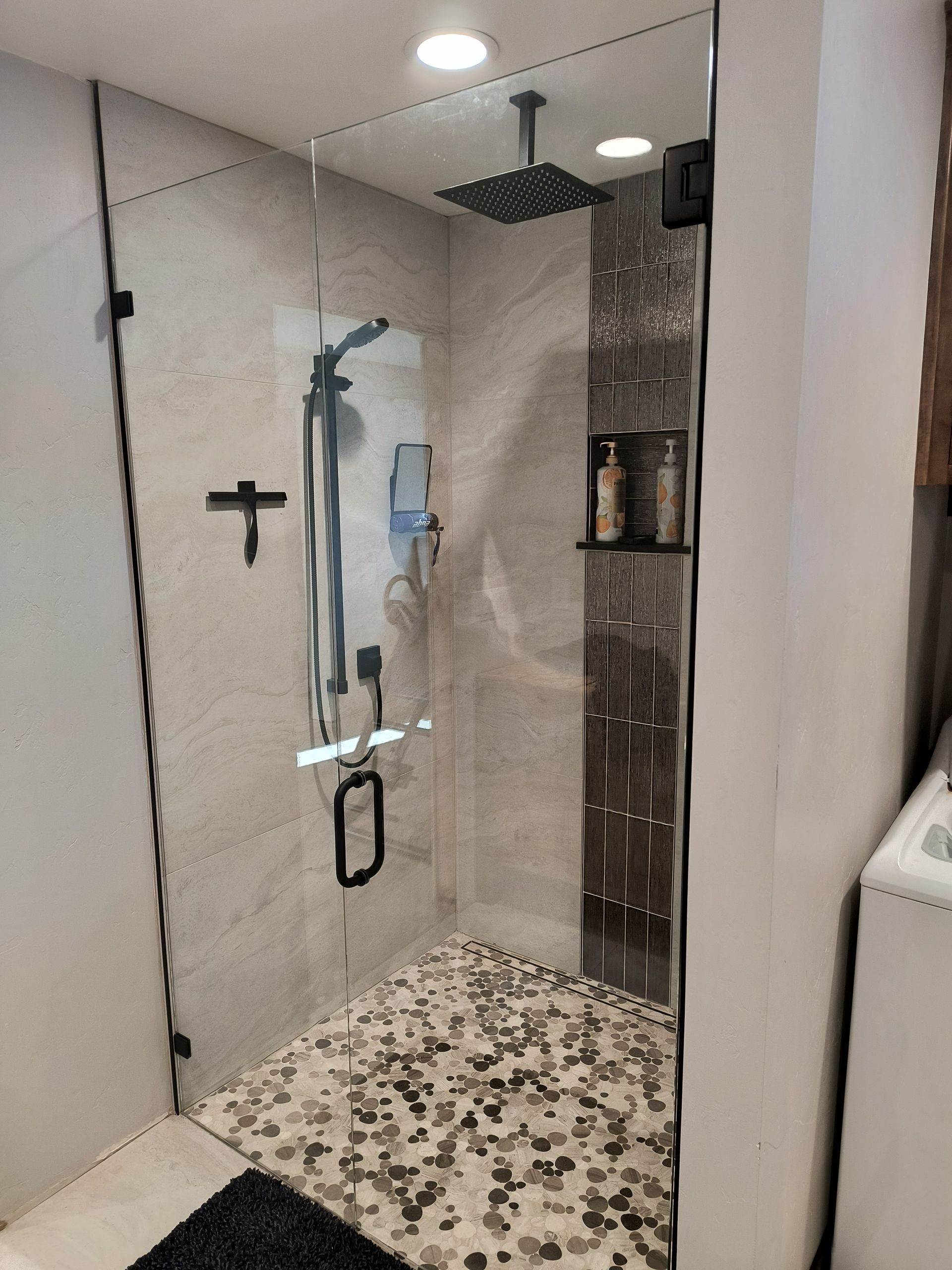 A bathroom with two sinks , a toilet , and a walk in shower.