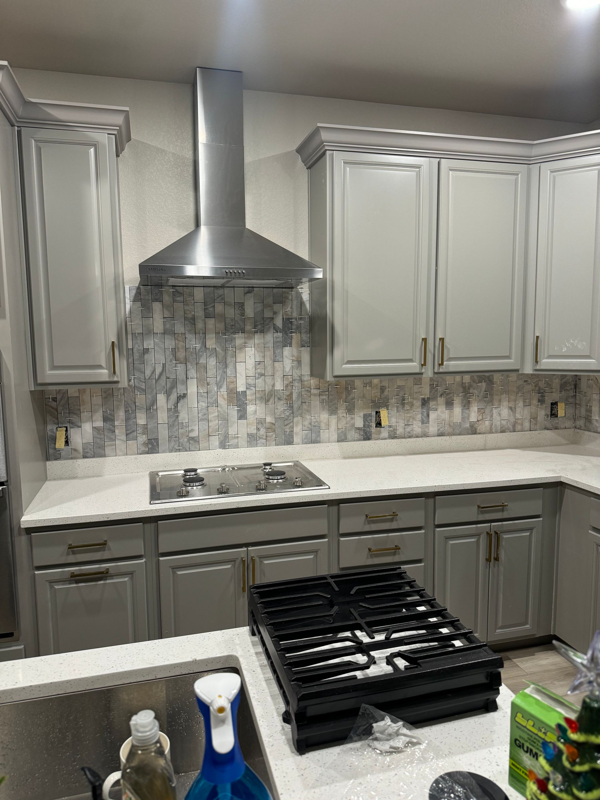 A kitchen with white cabinets , stainless steel appliances , and a large island.