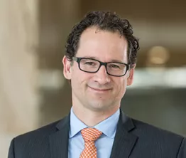 A man in a suit and tie is smiling for the camera.