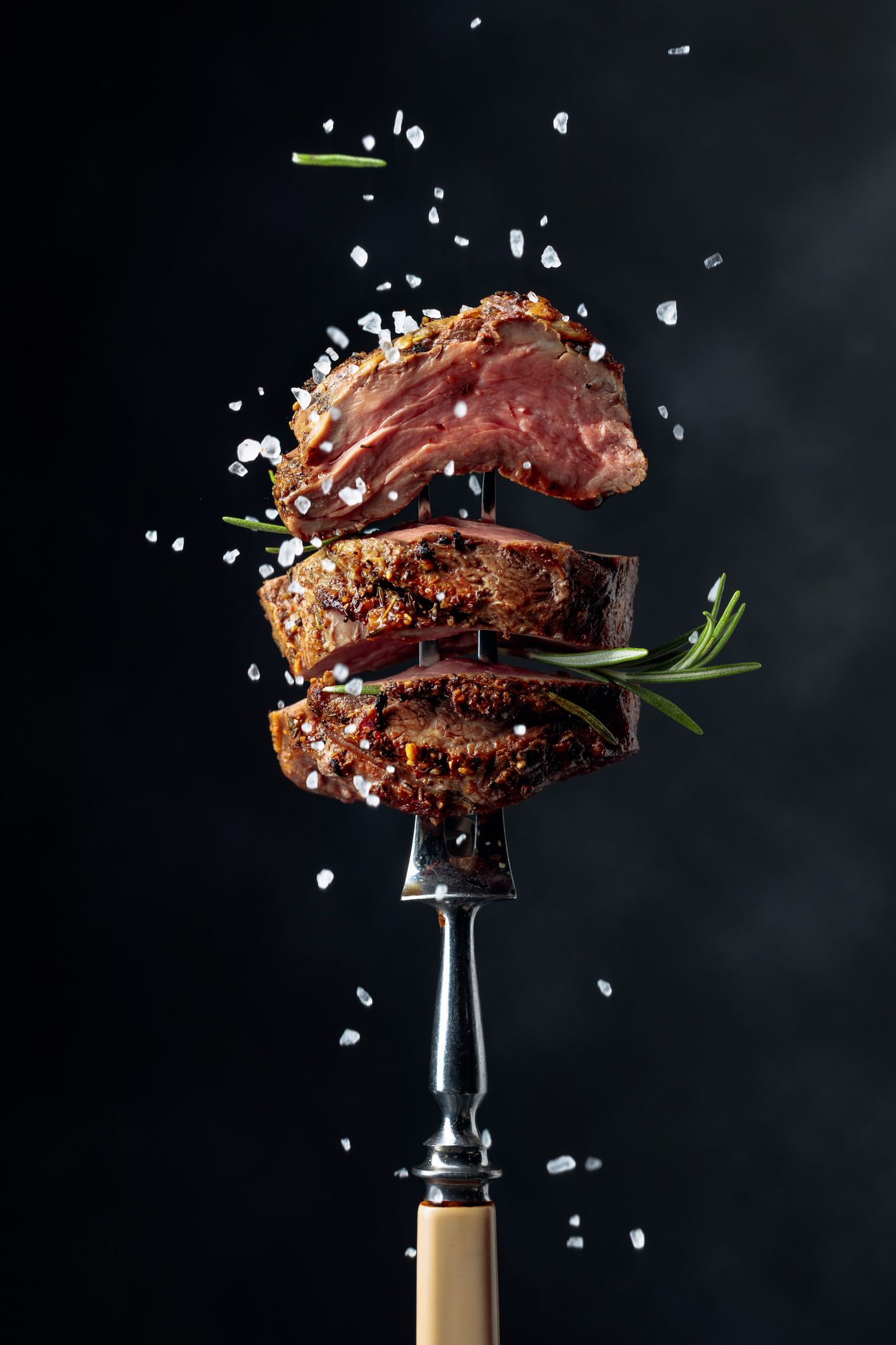 Un pezzo di bistecca è appoggiato su una forchetta.