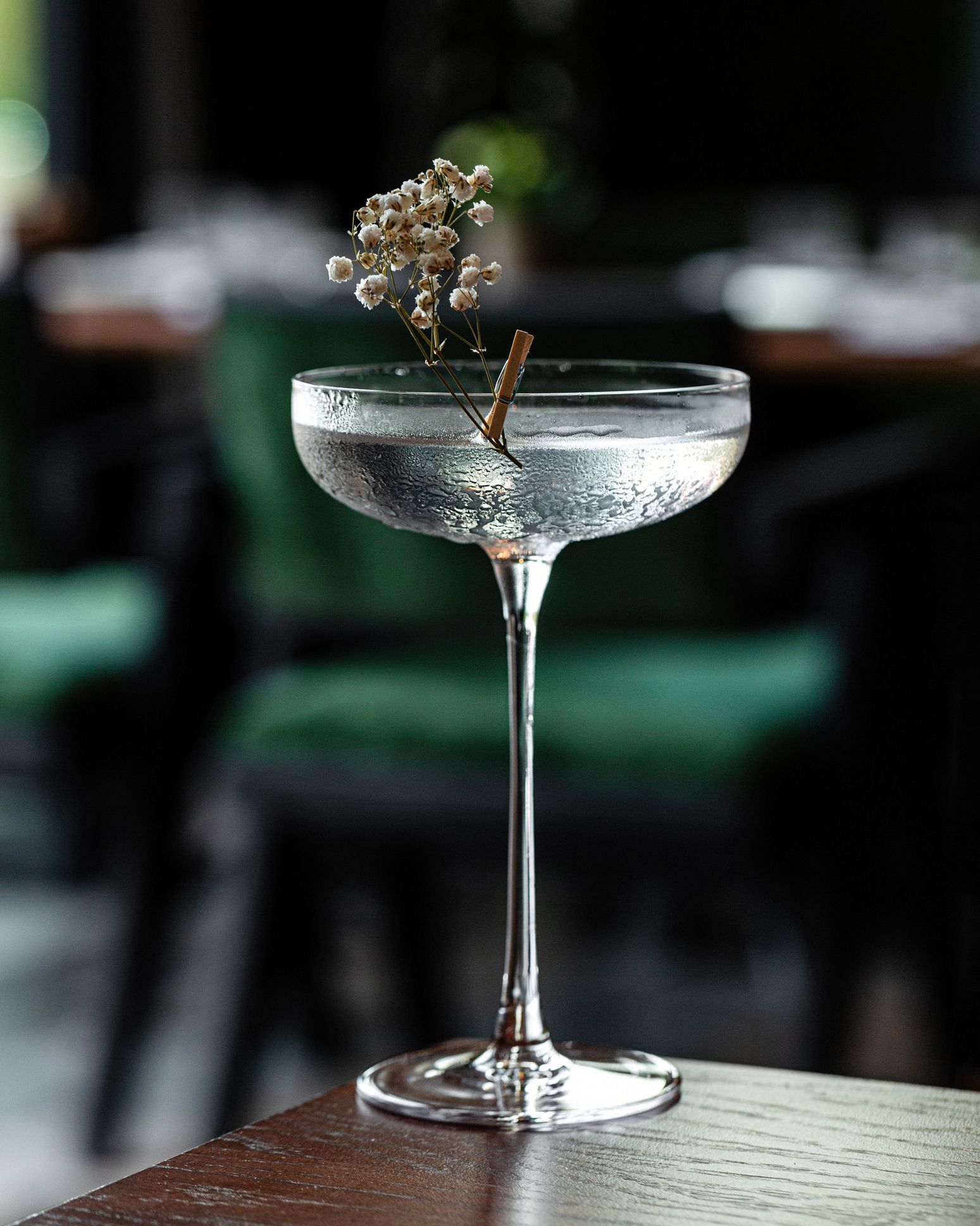 Su un tavolo c'è un bicchiere da martini con un fiore dentro.