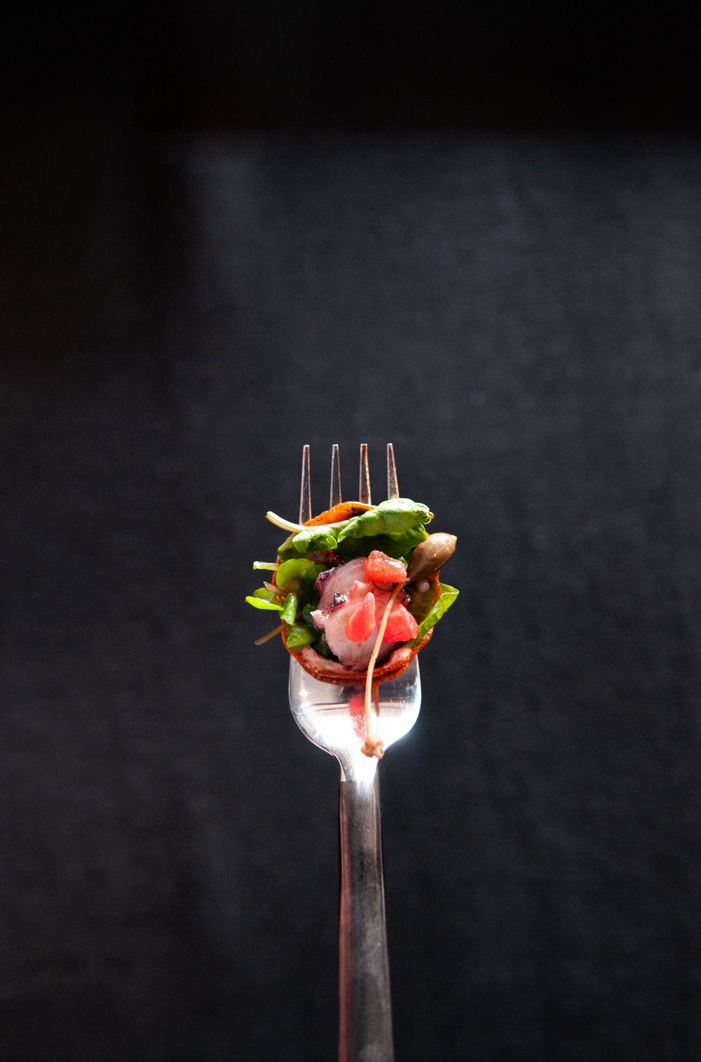 Una forchetta con un'insalata sopra su uno sfondo nero