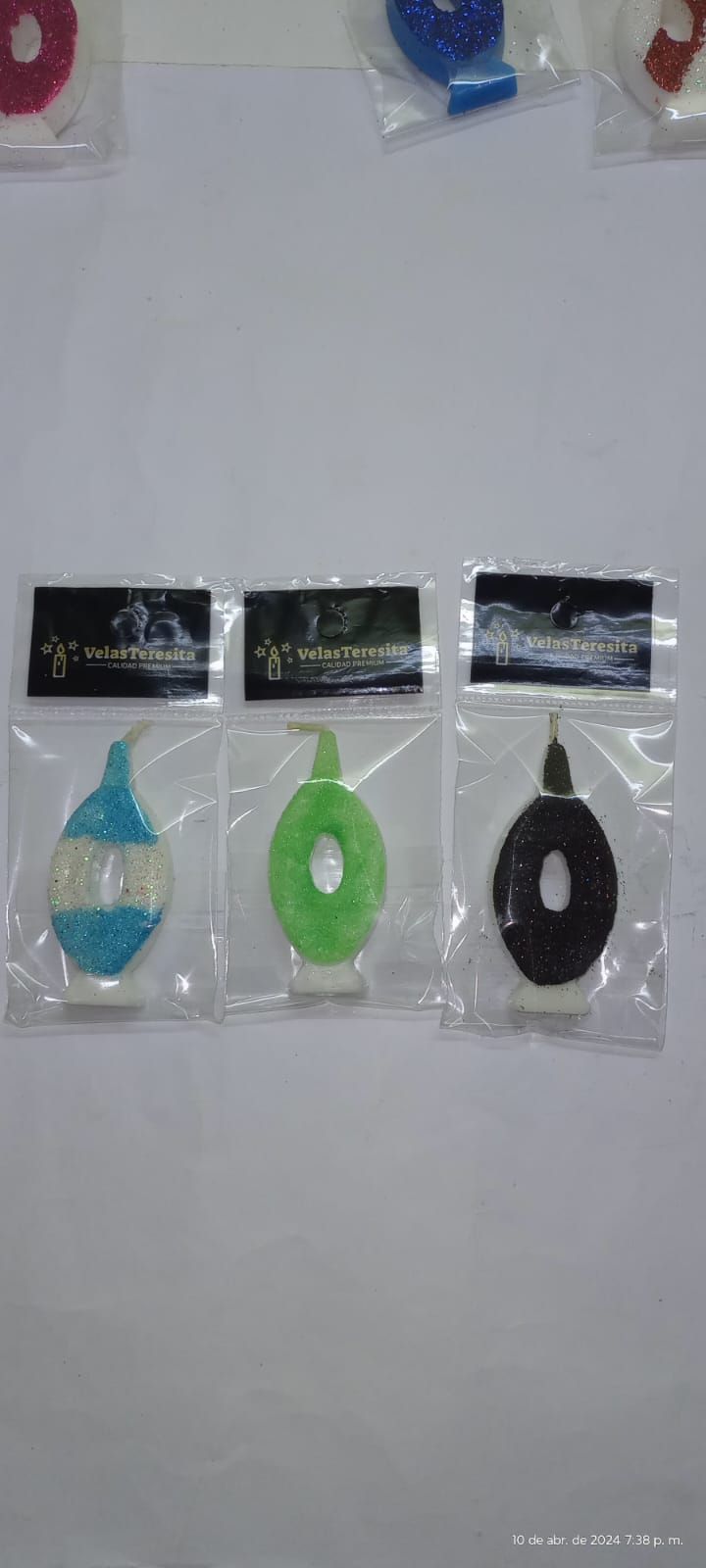 Tres velas de cumpleaños con forma de número en envase de plástico, de color azul, verde y negro.