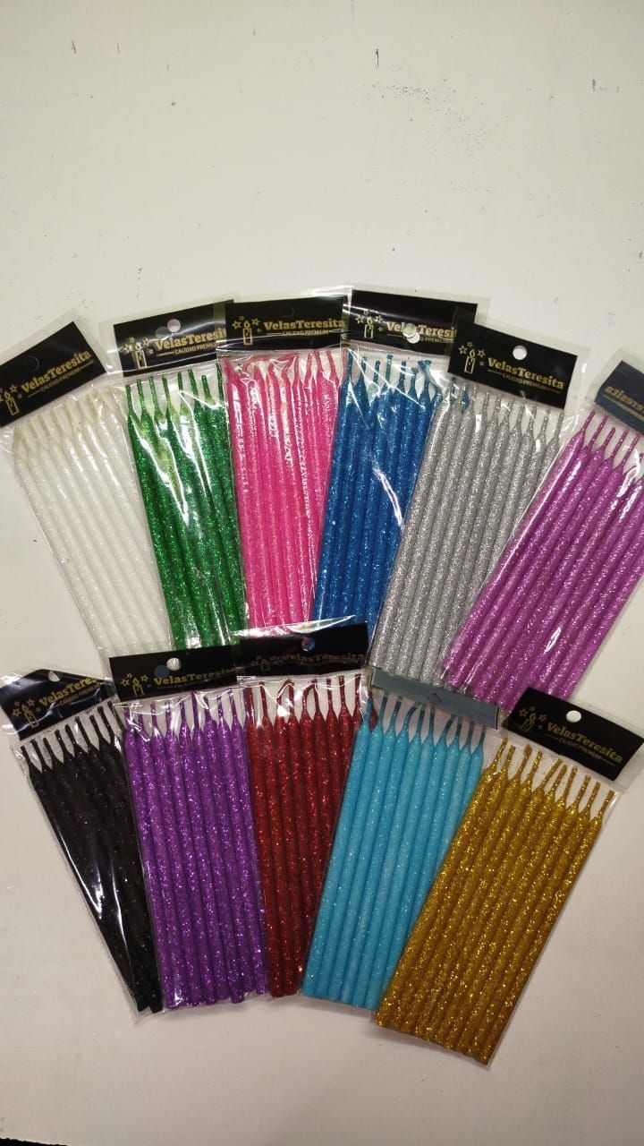 Paquetes de velas delgadas y brillantes en varios colores sobre un fondo blanco.