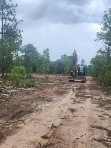 A bulldozer is driving down a dirt road.