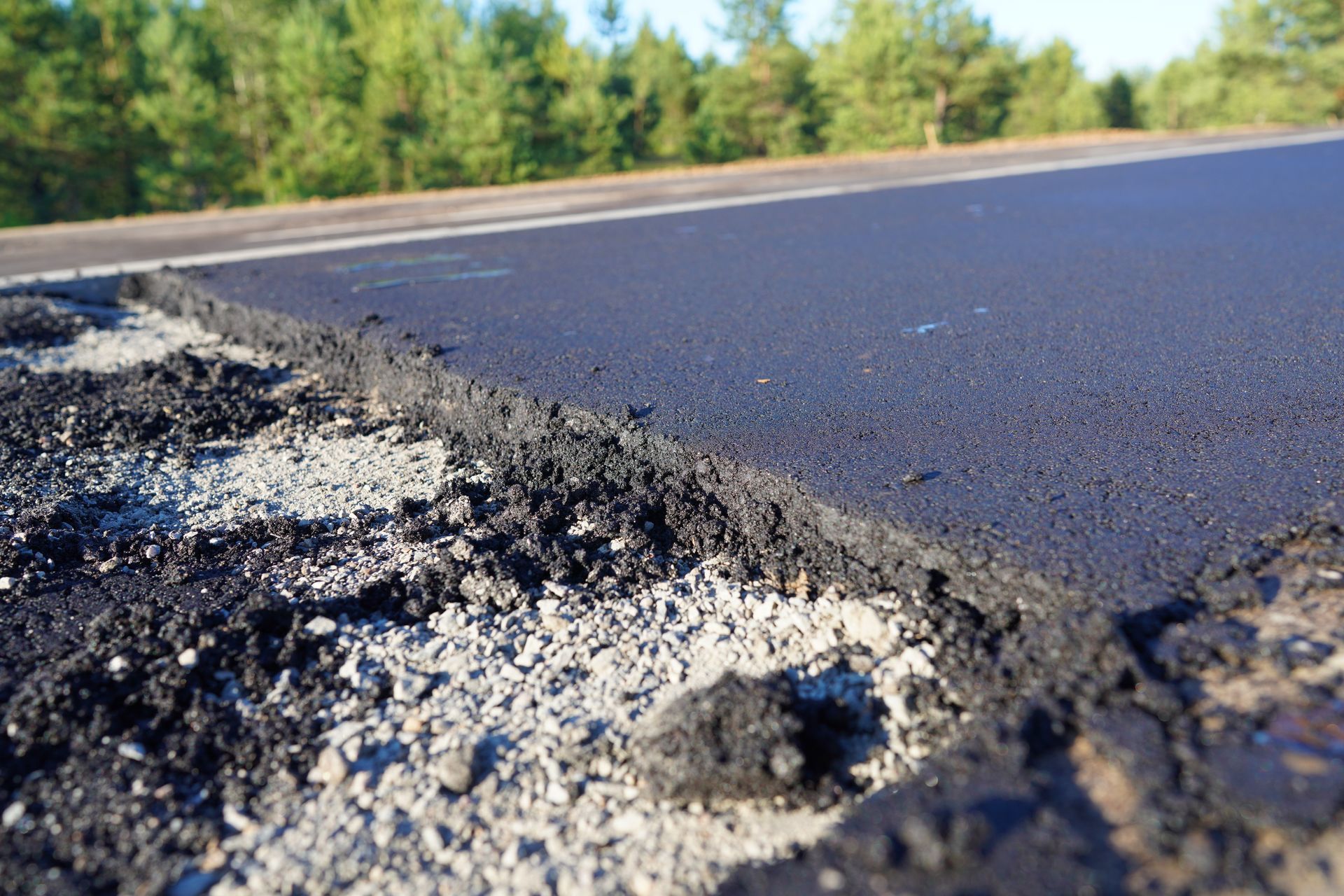 A close up of a pothole in the middle of a road.