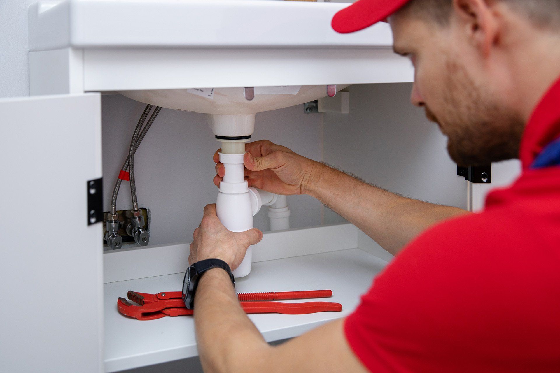 Plumber fixing pipes in home