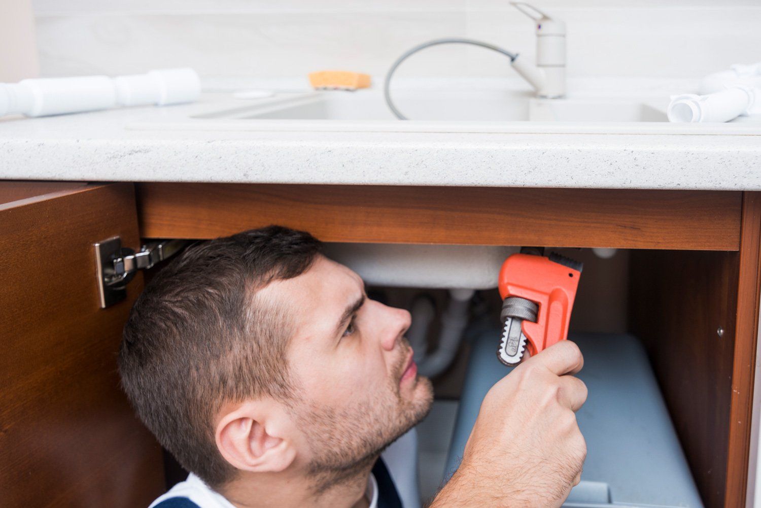 Plumber checking sink in home