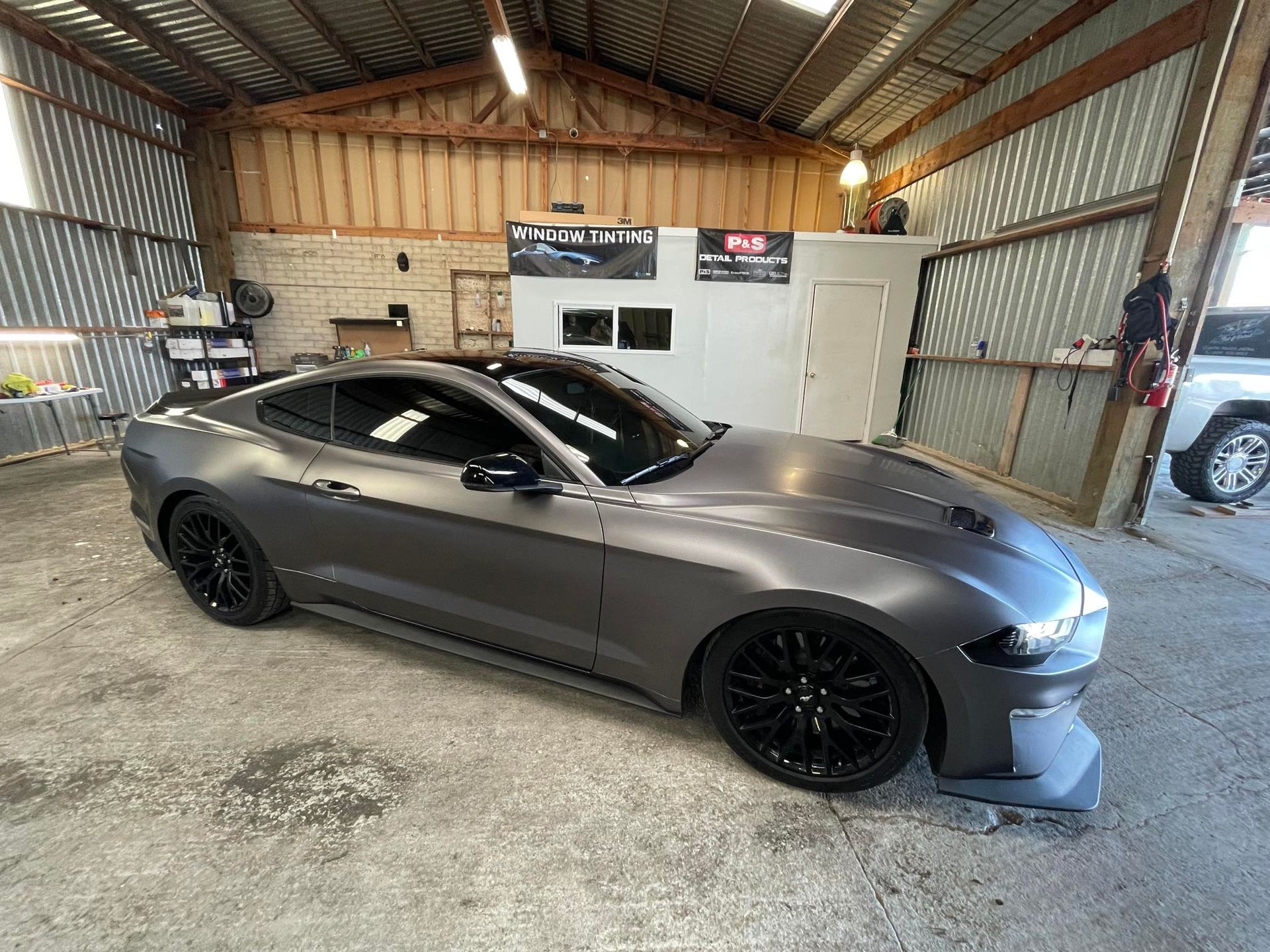 A black toyota tundra is parked in a driveway in front of a house.