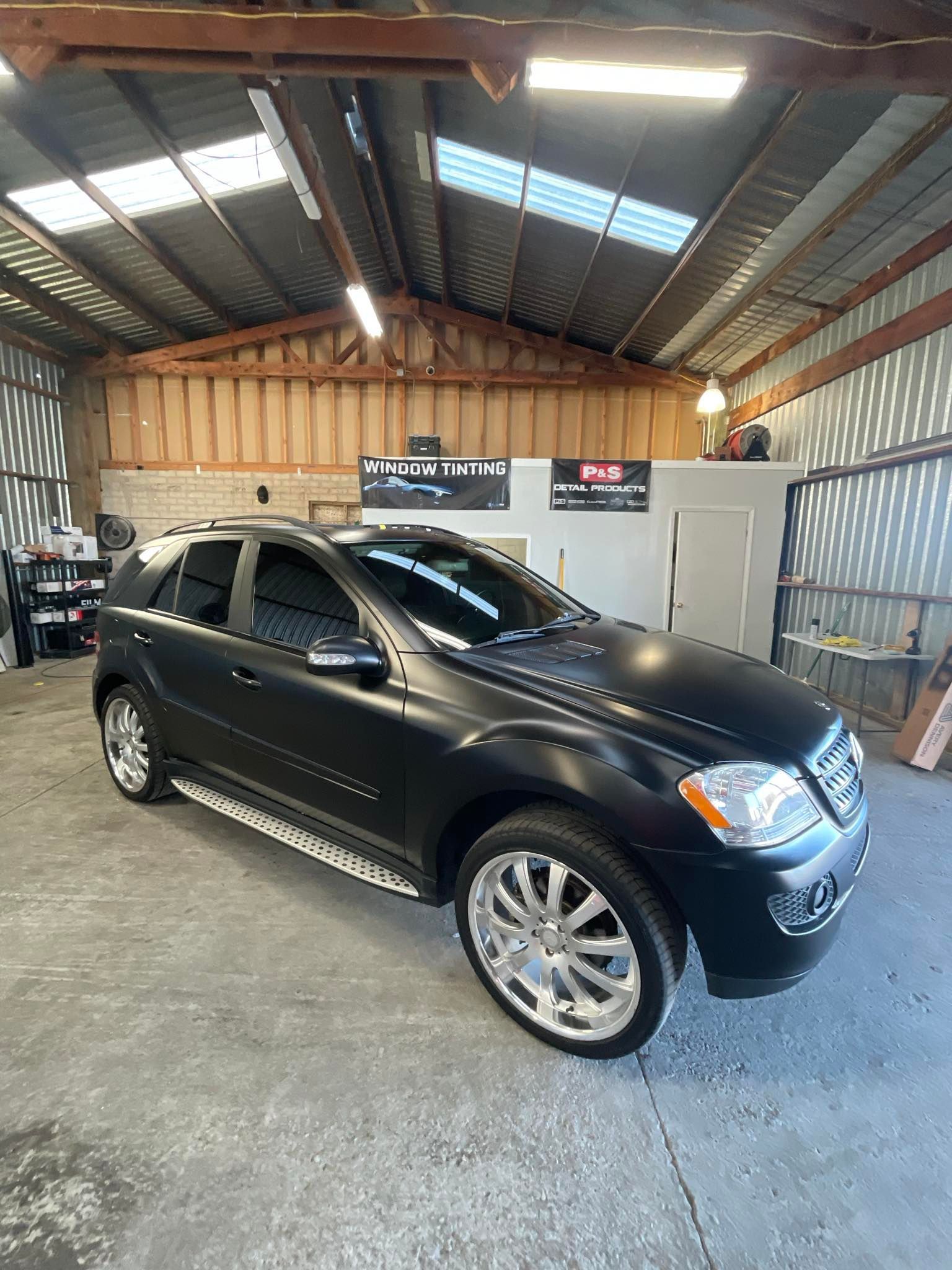 A black car is parked in a garage.