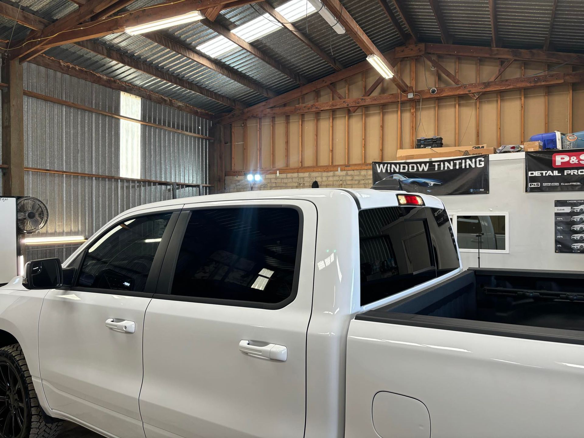 A black car is parked in a driveway next to a garage.
