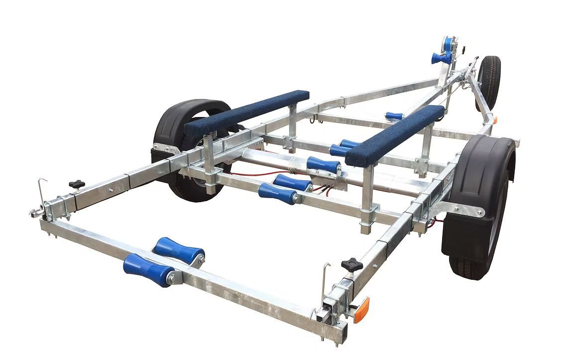 Galvanized steel boat trailer with blue rollers and bunks, black tires, and orange light.