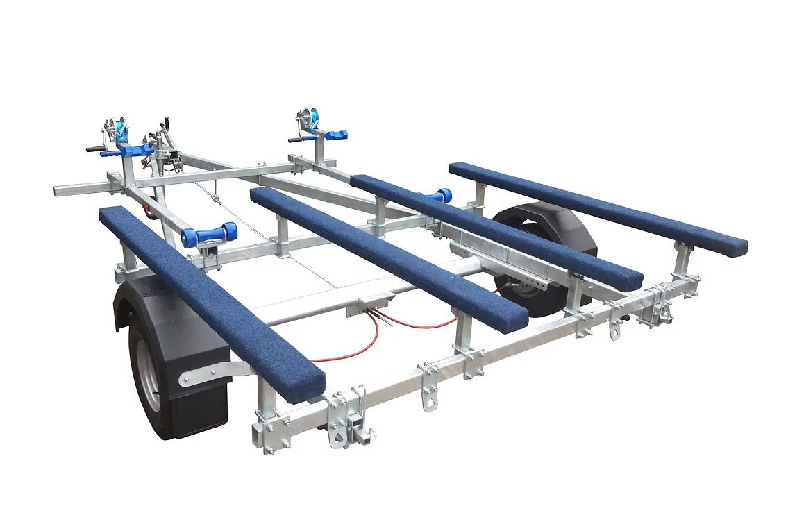 Boat trailer, metal frame with blue padded supports and rollers, on white background.