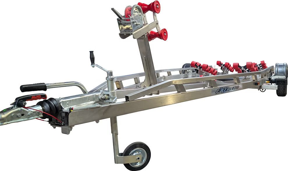 Boat trailer with red rollers, a winch, and a hitch, on a white background.